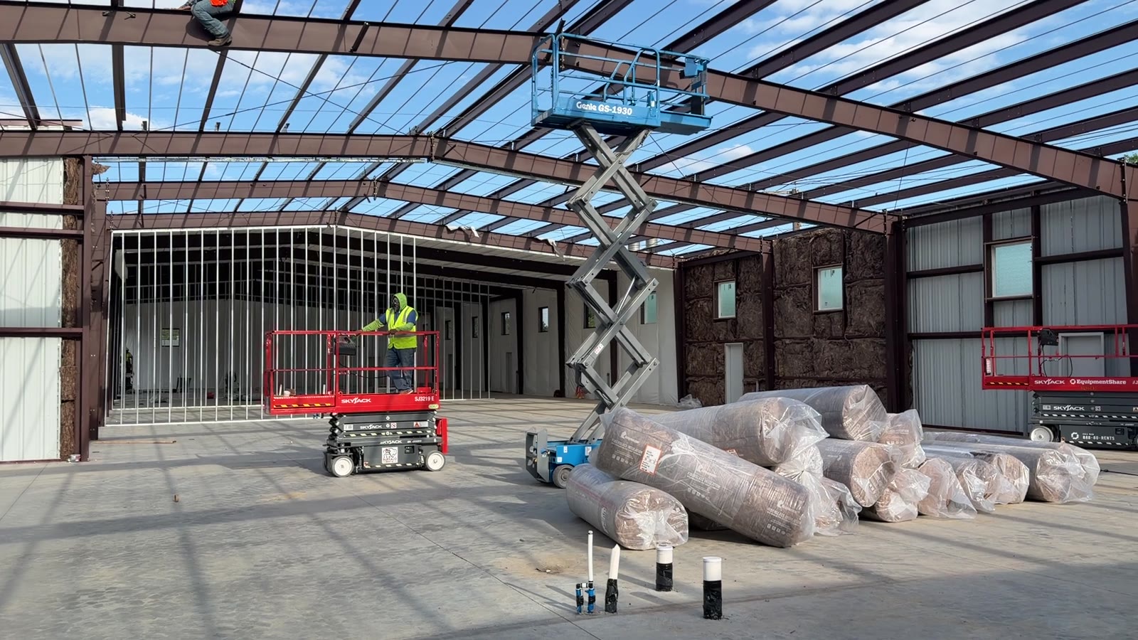 Crews installing insulation and panels in a commercial interior