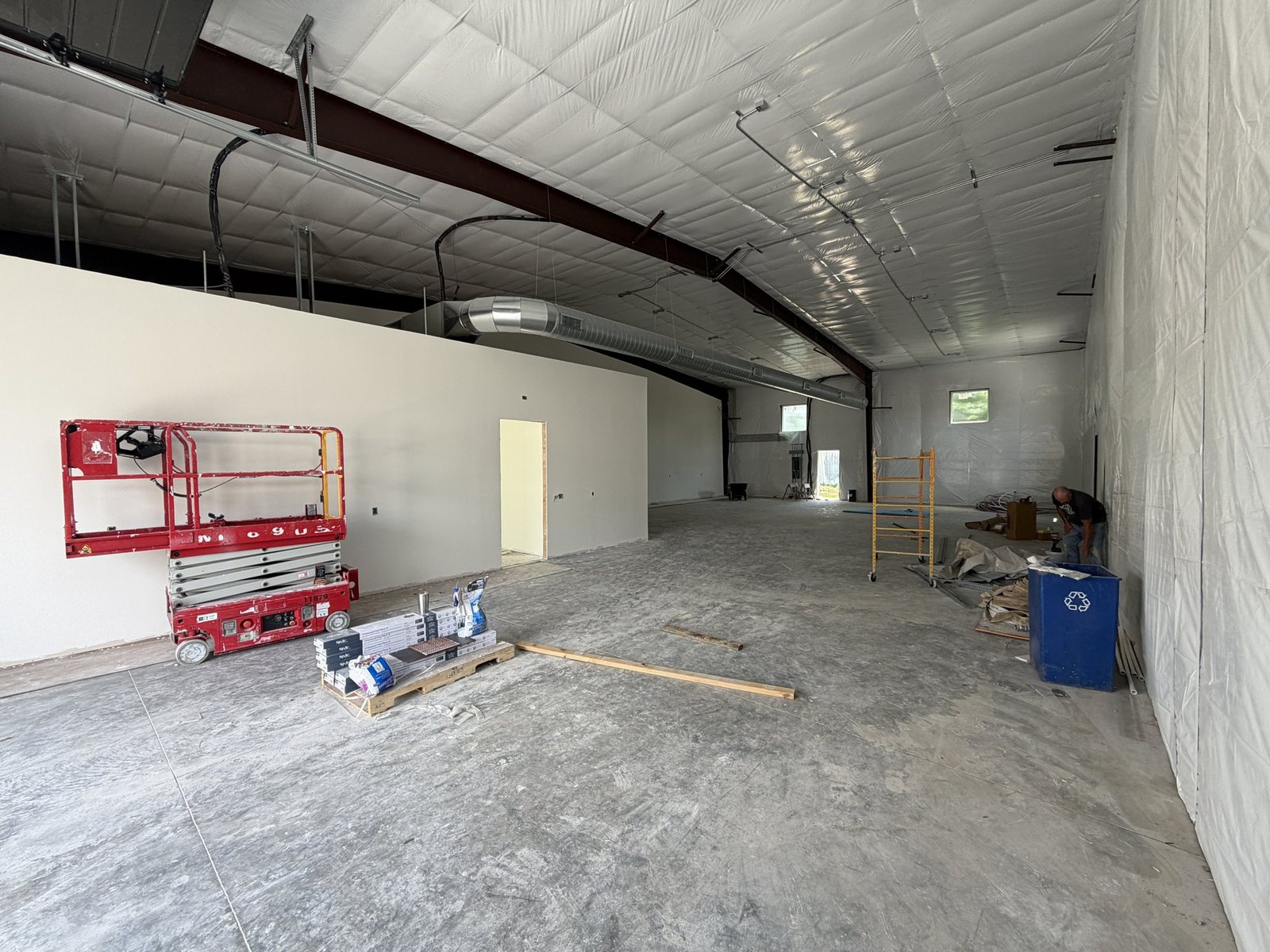 Active commercial interior bay with scissor lift and staged materials