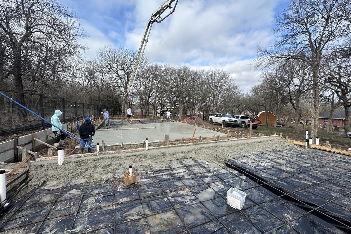 Crew placing a concrete foundation pour with a boom pump